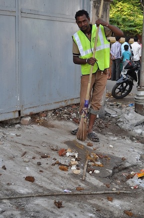 A municipality worker in the city of Ahmedabad removes human excreta from roadside.
